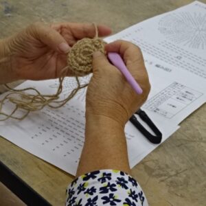 編み図に従って編み込んでいく受講者